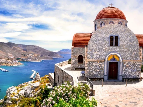 Abgelegene Kirche mit rotem Dach auf einer Klippe am Meer