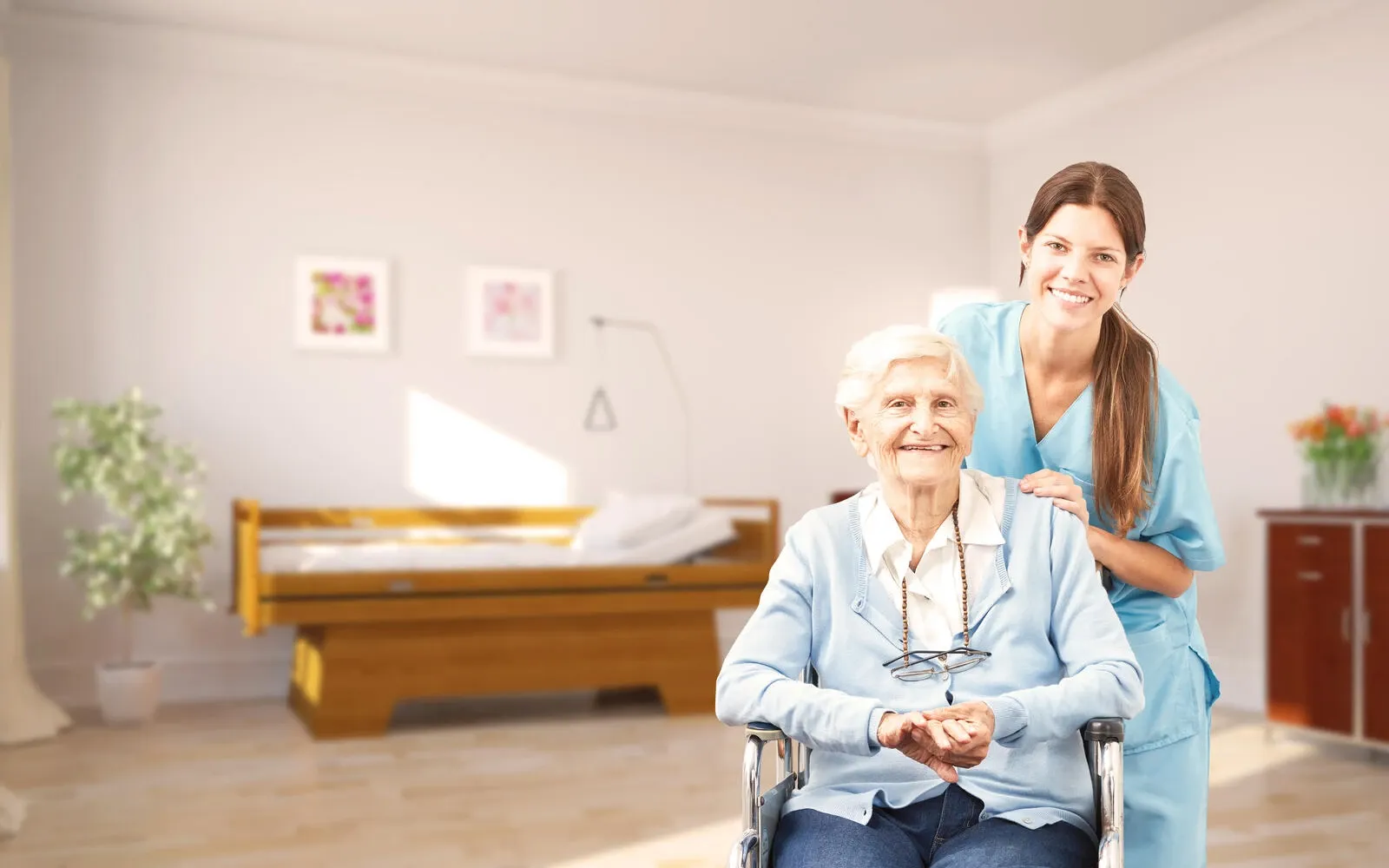 Seniorin im Rollstuhl mit Pflegekraft im Pflegeheim