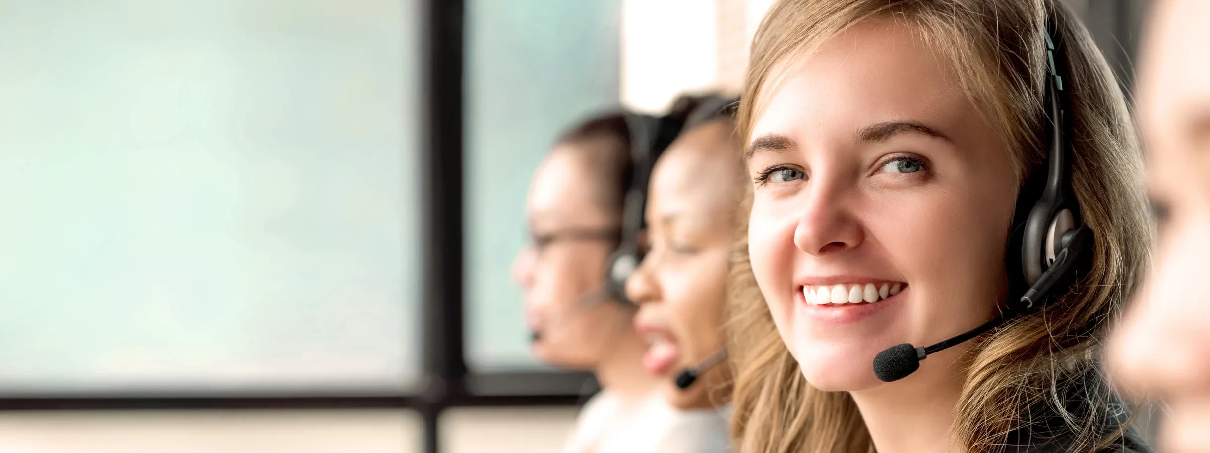 Schöne kaukasische Frau, die im Callcenter mit internationalen Kollegen arbeitet